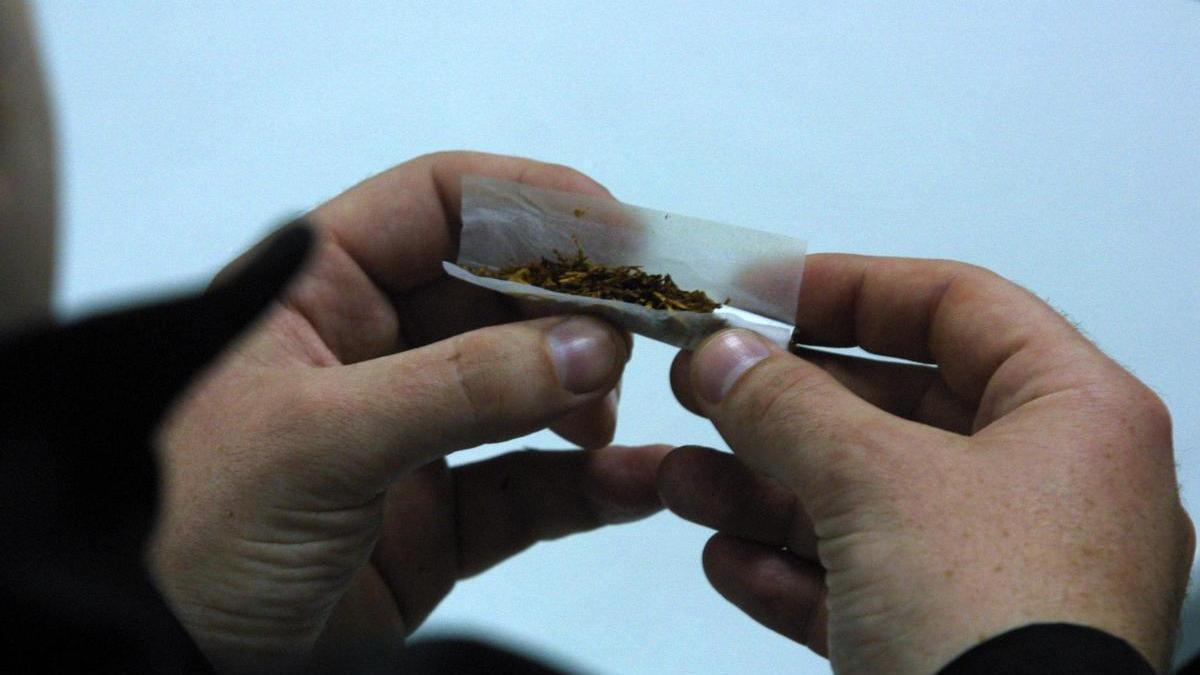 Un joven, liando un cigarro en una imagen de archivo.