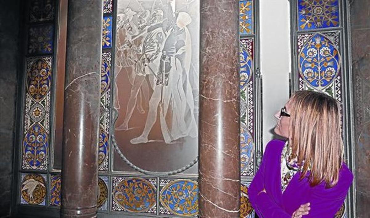 Carmen Perella, la directora del Palau Güell, al costat del vidre gravat a l’àcid que decora la sala de confiança del palau.