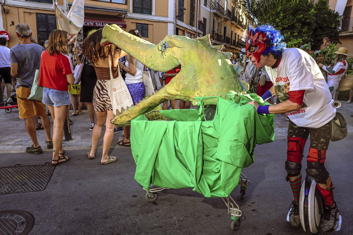 Vecinos de la Calatrava y Canamunt, muchos vestidos de verde y con ramas de árboles, se unen durante sus cercavilas para homenajear a los bellasombras talados en la plaza Llorenç Villalonga.