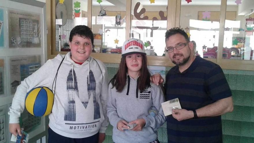 El representante de Fasfil, Carlos Blanco, ayer junto a dos alumnos en el colegio Nuestra Señora del Rosario de Ribadesella.