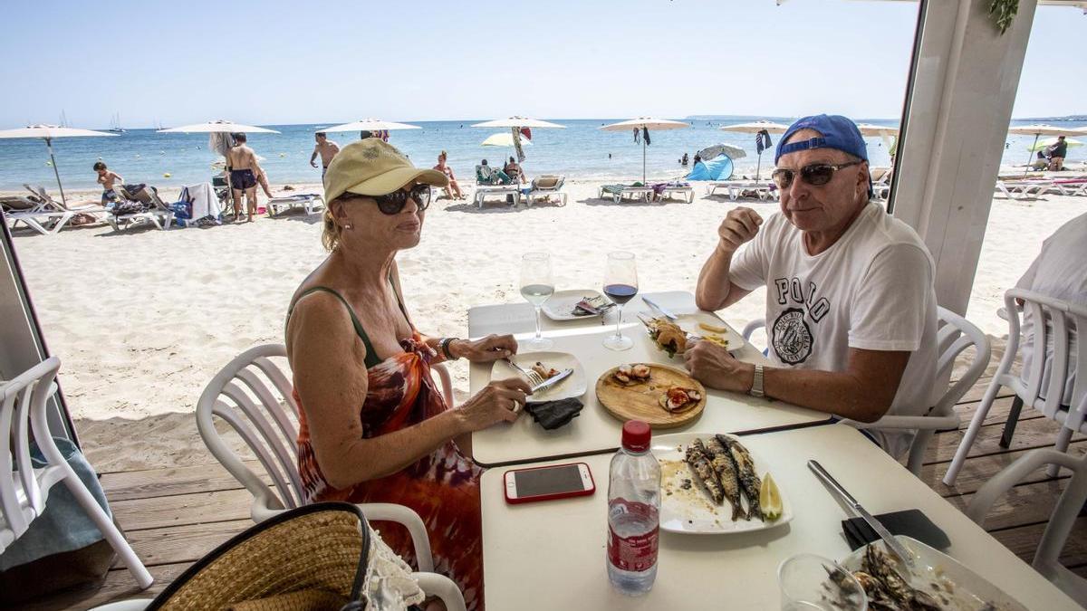 Dos clientes comen sardinas en el chiringuito de la playa de la Albufereta