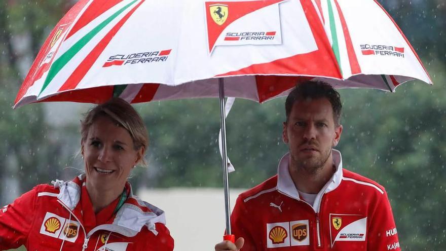 Sebastian Vettel se protege de la lluvia ayer en el circuito de Shanghai.