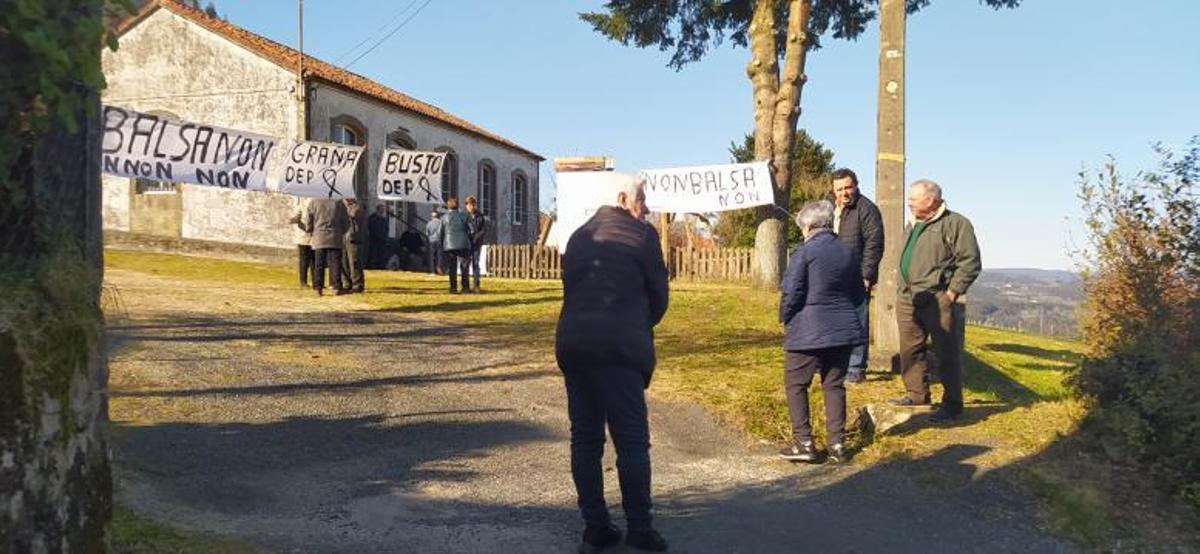 Vecinos en la entrada del local social de Cornanda repleto de pancartas contra el posible embalse. ECG