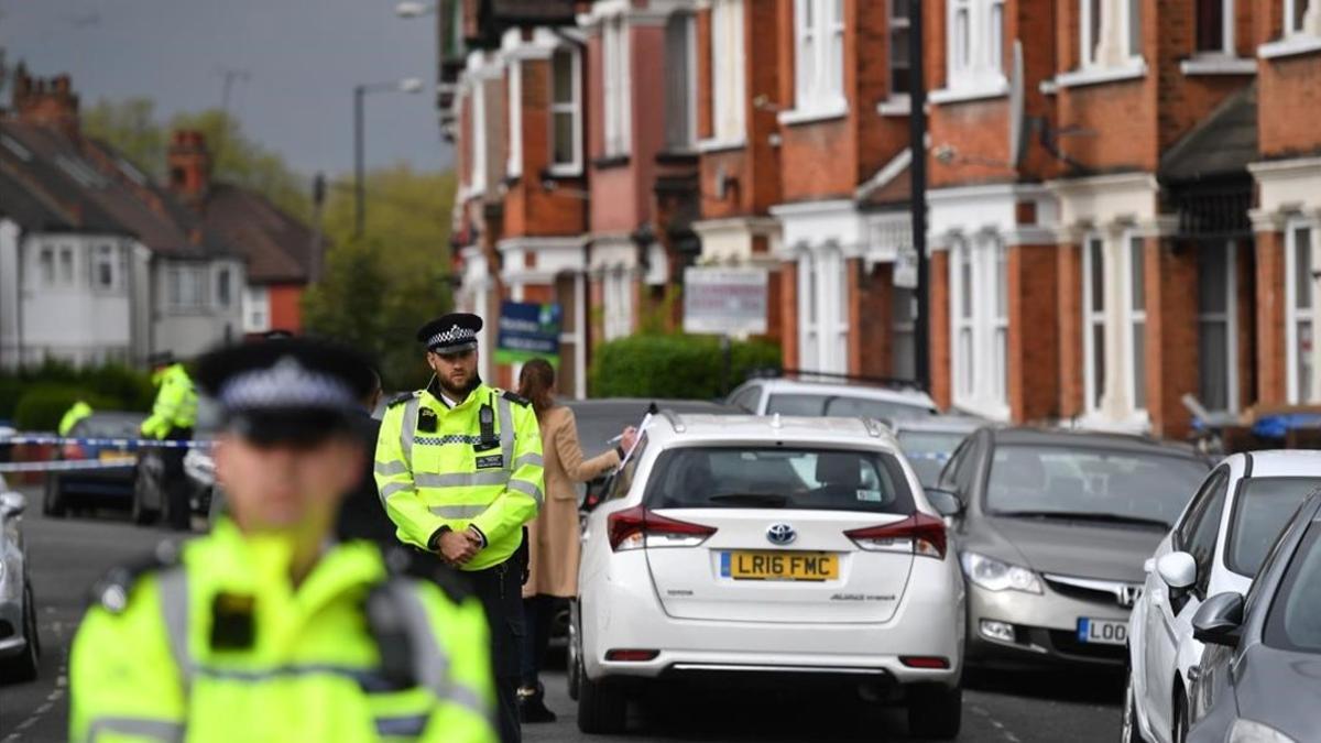 Agentes británicos mantiene un cordón policial en la calle residencial del noroeste de Londres donde tuvo lugar el tiroteo durante una operación antiterrorista, el 28 de abril, en Londres.