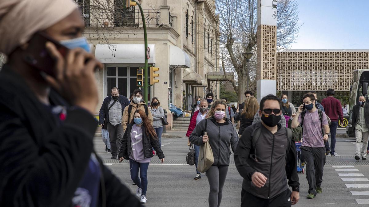 Ciudadanos con mascarilla cruzan las Avenidas a la altura de la plaza de España