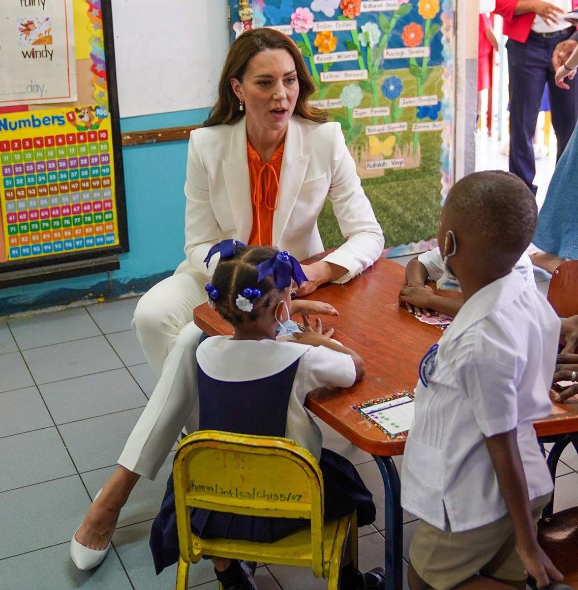 Kate Middleton con traje de chaqueta blanco y blusa naranja