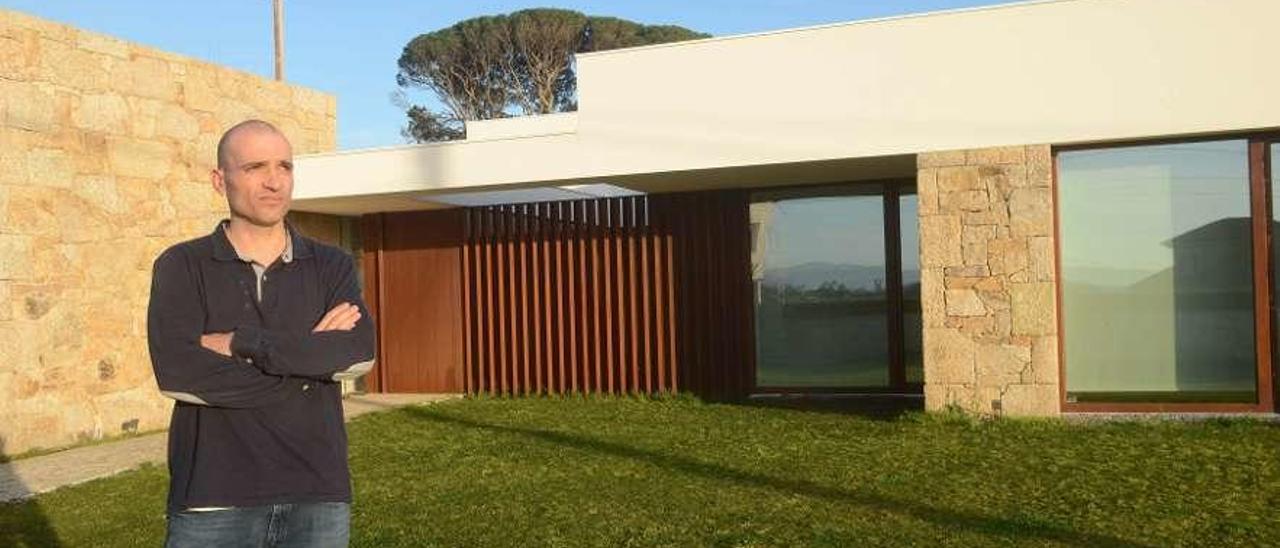 Paco Galiñanes, ante la vivienda diseñada en Corvillón y que concurre a los premios COAG . // Noé Parga