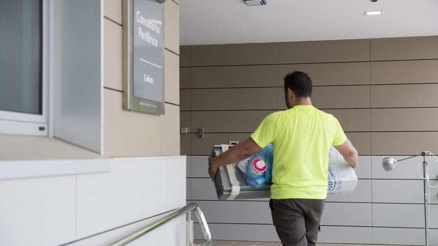 Un operario, ayer, introduciendo la nueva maquinaria en el centro de salud de Colloto.