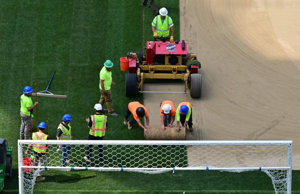Los trabajadores instalan césped en el campo en el SoFi Stadium en Inglewood, California, antes de su cambio de nombre temporal al Estadio de Los Ángeles para la Copa del Mundo el 13 de mayo de 2026.