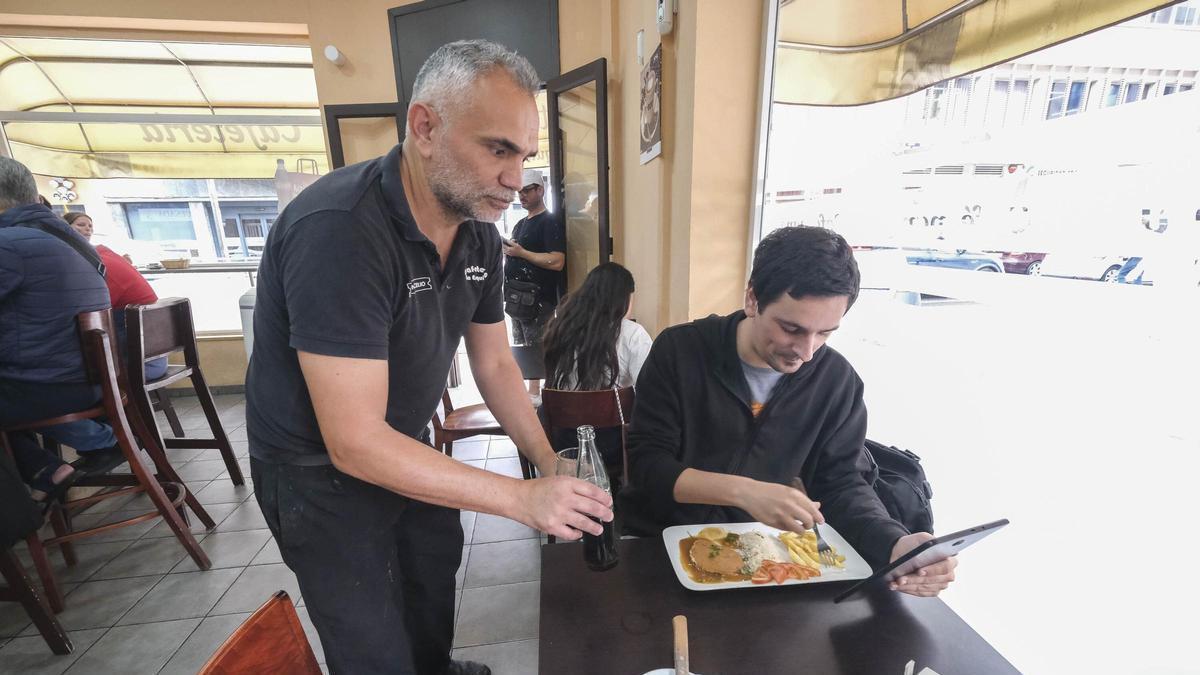 Un camarero sirve a un cliente en una mesa.