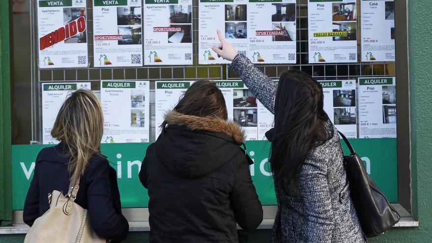 Tres mujeres observan el escaparate de una inmobiliaria de Vigo // José Lores