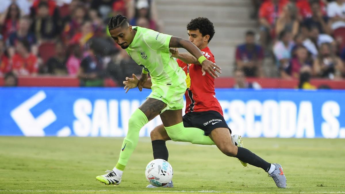PALMA DE MALLORCA, 16/08/2025.- El defensa del Mallorca Mateu Morey (d) pelea un balón ante el delantero brasilero del Barcelona Raphinha este sábado, durante la primera jornada de LaLiga EA Sports, entre el RCD Mallorca y el FC Barcelona, en el estadio de Son Moix de Palma de Mallorca. EFE/ Cati Cladera