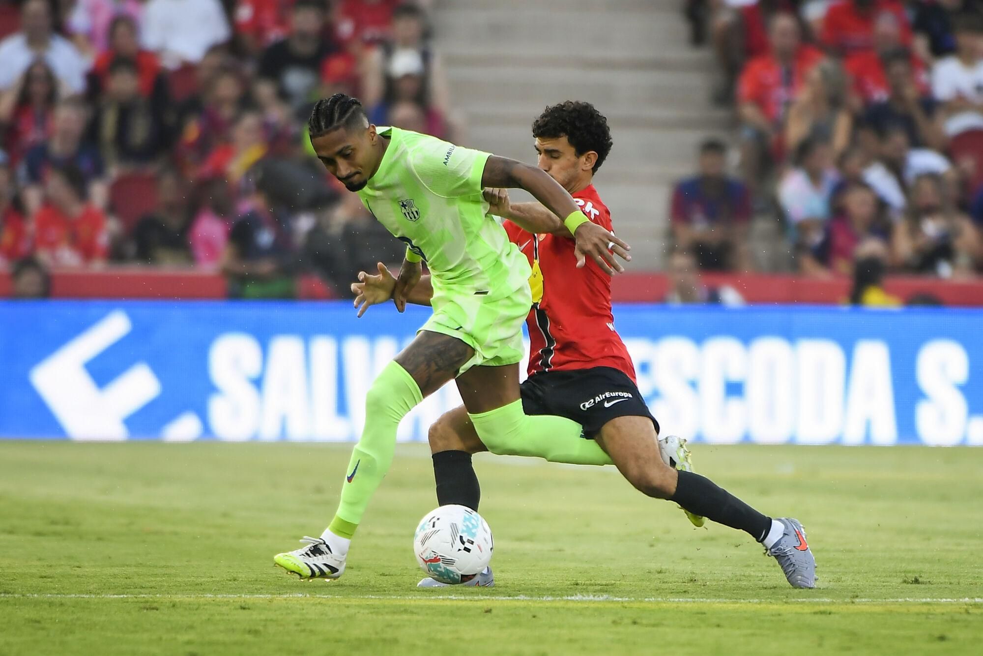 PALMA DE MALLORCA, 16/08/2025.- El defensa del Mallorca Mateu Morey (d) pelea un balón ante el delantero brasilero del Barcelona Raphinha este sábado, durante la primera jornada de LaLiga EA Sports, entre el RCD Mallorca y el FC Barcelona, en el estadio de Son Moix de Palma de Mallorca. EFE/ Cati Cladera