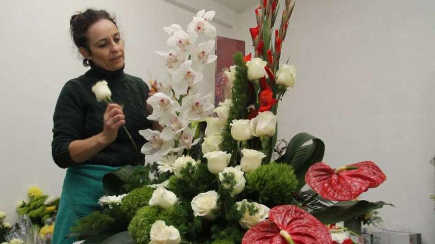 Luz González prepara un centro de flores en su negocio de la calle Colón. // Bernabé/Gutier