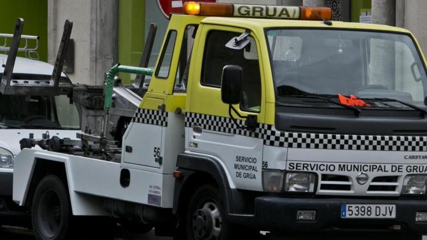 Grúa municipal cargando un automóvil en el centro de Alicante