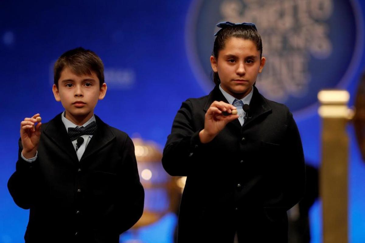 Los niños del colegio de San Ildefonso Nerea Pareja y Luis Alcides muestran las bolas con el número 41.710, que ha sido agraciado con el primero de los dos cuartos premios,