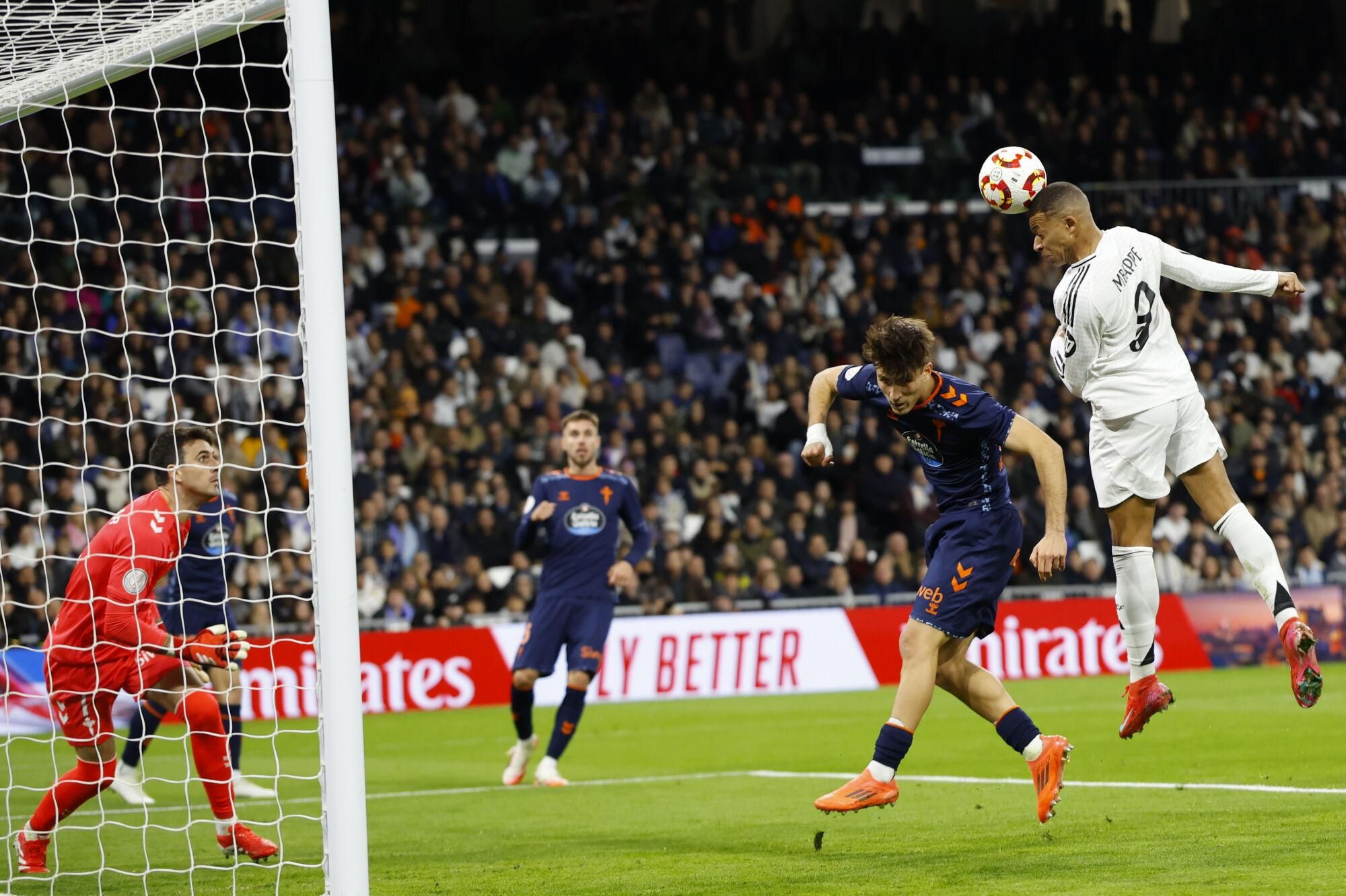 Real Madrid's Kylian Mbappe, right, heads a ball next to Celta's Javi Rodriguez during a Copa del Rey round of 16 soccer match at the Santiago Bernabeu stadium in Madrid, Spain, Thursday, Jan. 16, 2025. (AP Photo/Pablo Garcia). EDITORIAL USE ONLY / ONLY ITALY AND SPAIN