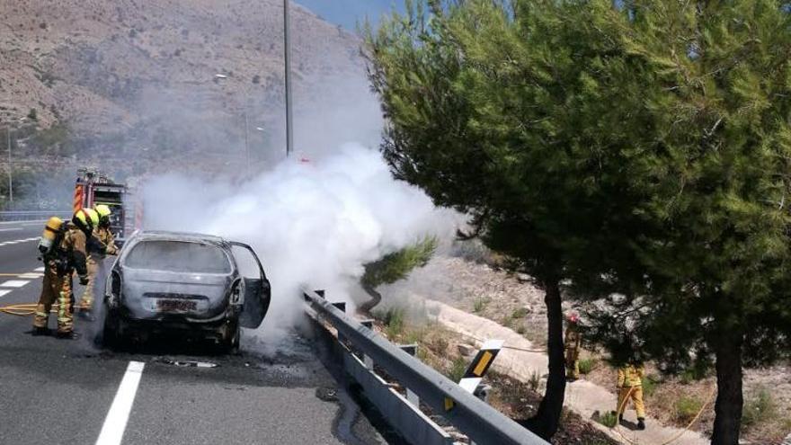 Extinción de las llamas que han calcinado el coche en la subida del Maigmó, en la A-7 en Tibi.