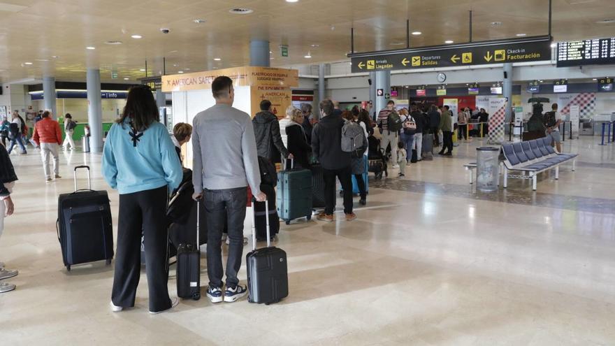 Colas de pasajeros para facturar, ayer, en el aeropuerto de Asturias.