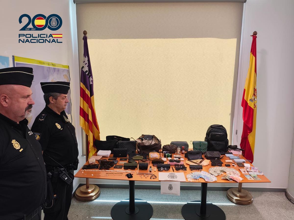 Agentes de la Policía Nacional del aeropuerto, con el botín requisado a los delincuentes.