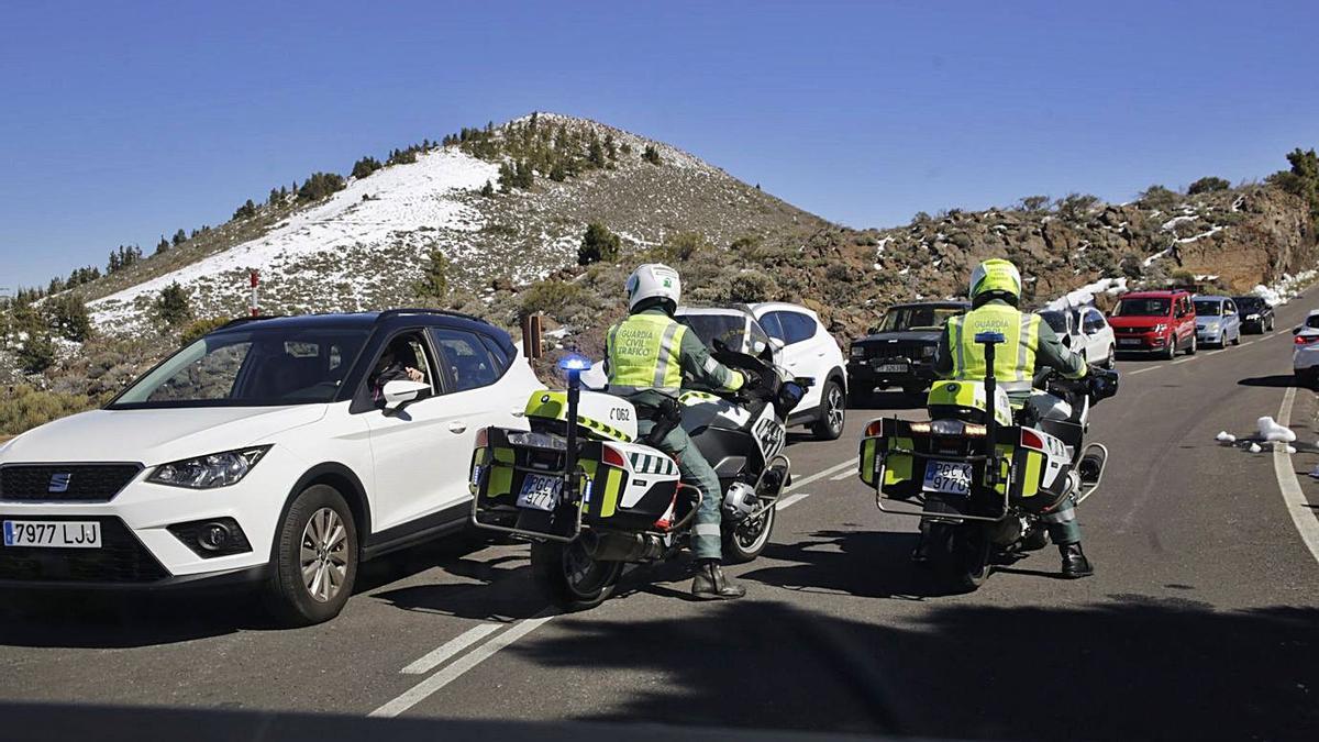 Cola de coches y, en sentido contrario, pareja de la Guardia Civil, el martes en el Parque Nacional del Teide.