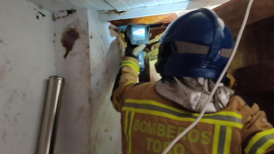 Un bombero revisa el interior de la vivienda afectada por el fuego