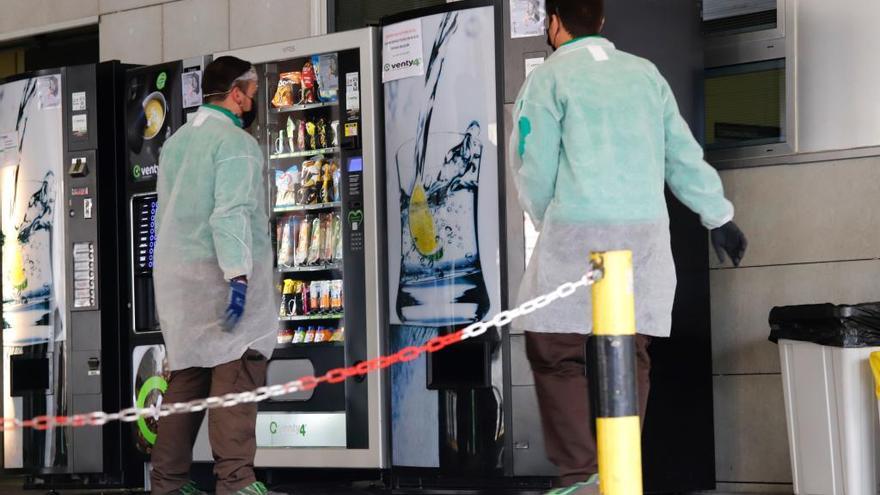 Dos sanitarios hacen un descanso para tomar algo en el Hospital Reina Sofía de Murcia.