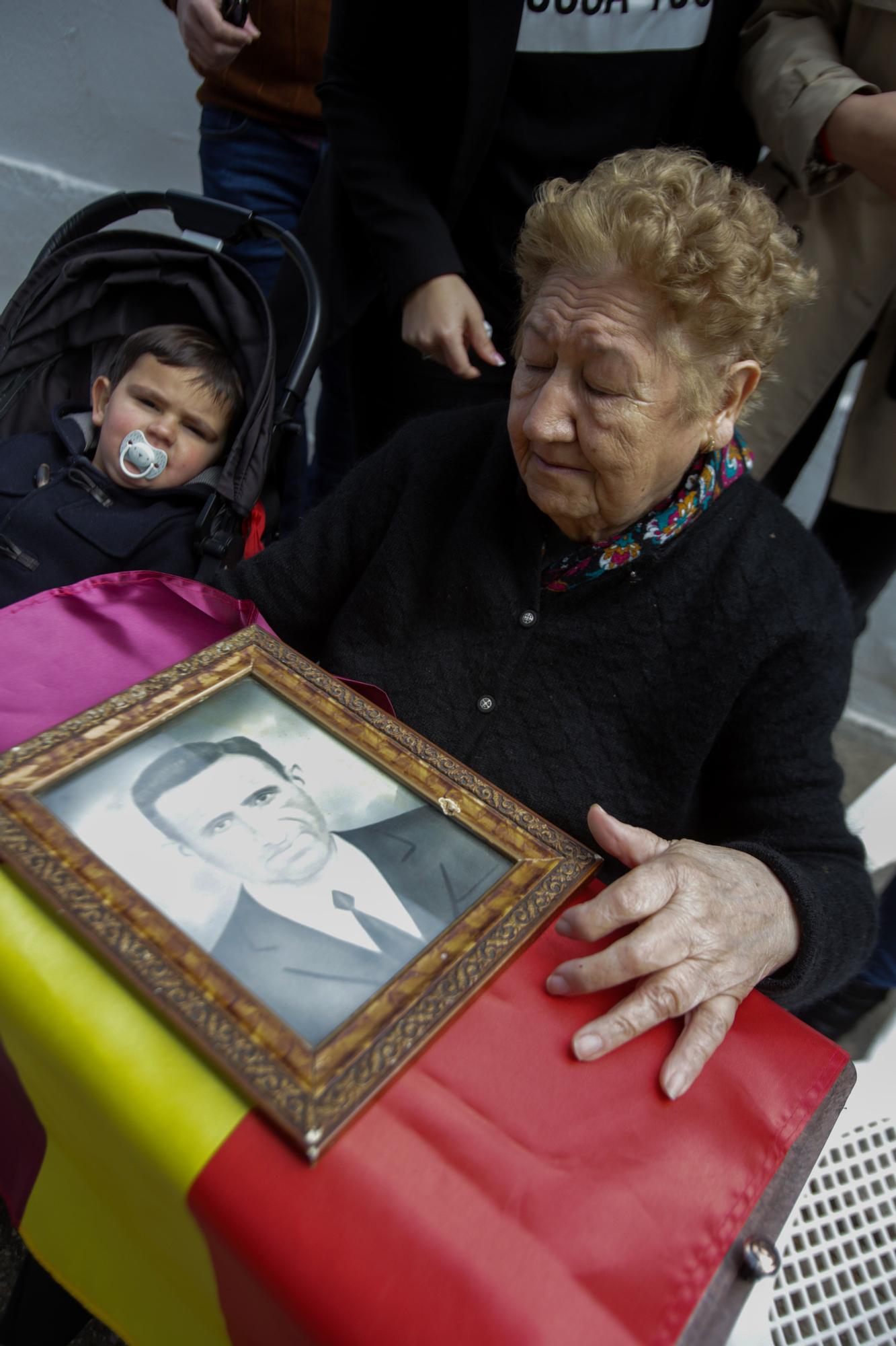 Remedios junto a su bisnieto y la foto de su padre.