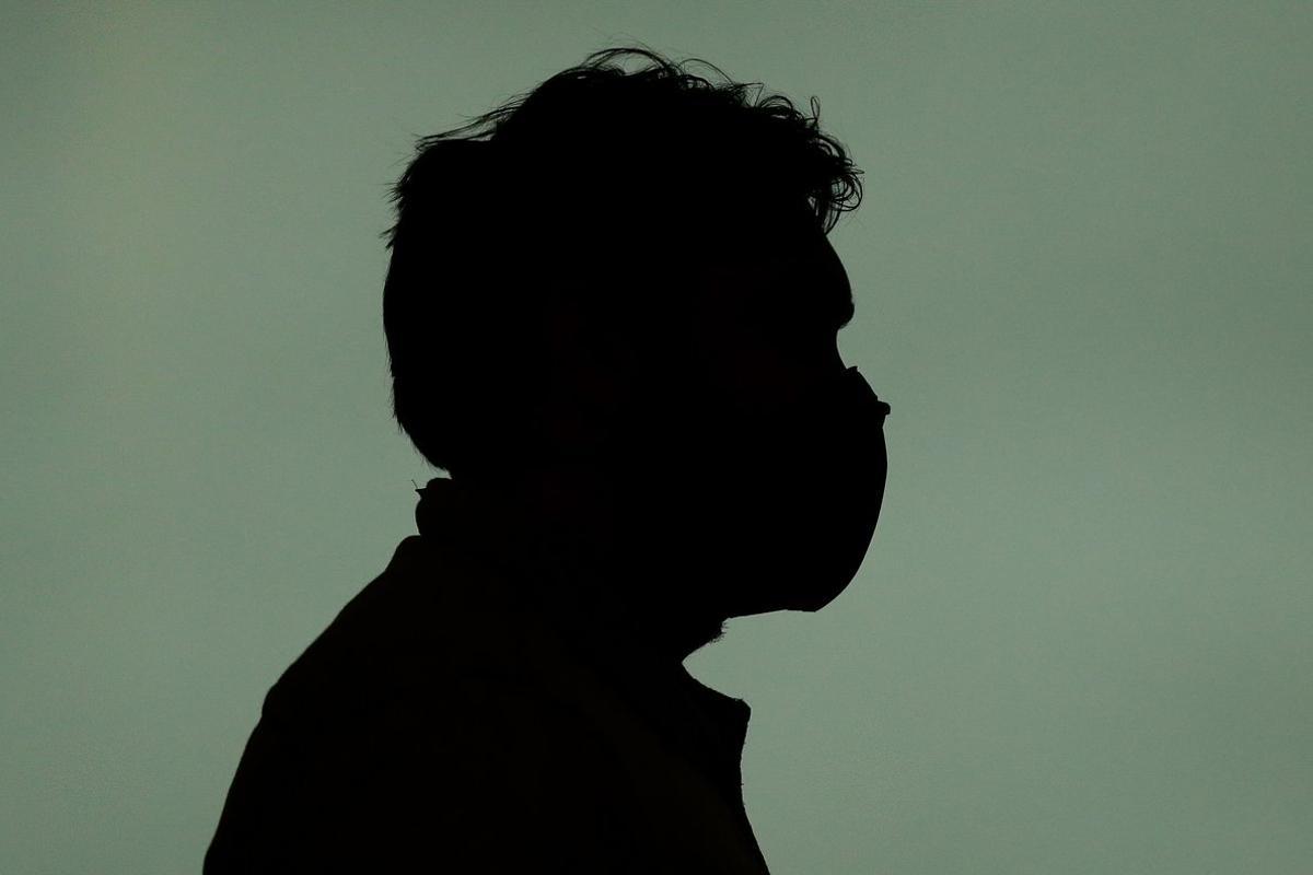 A person wearing a protective mask walks at El Prat airport in Barcelona on March 16, 2020. - After the COVID-19 pandemic began in China late last year, Europe in recent weeks emerged as the biggest flashpoint and the death toll on the continent surged over the weekend.