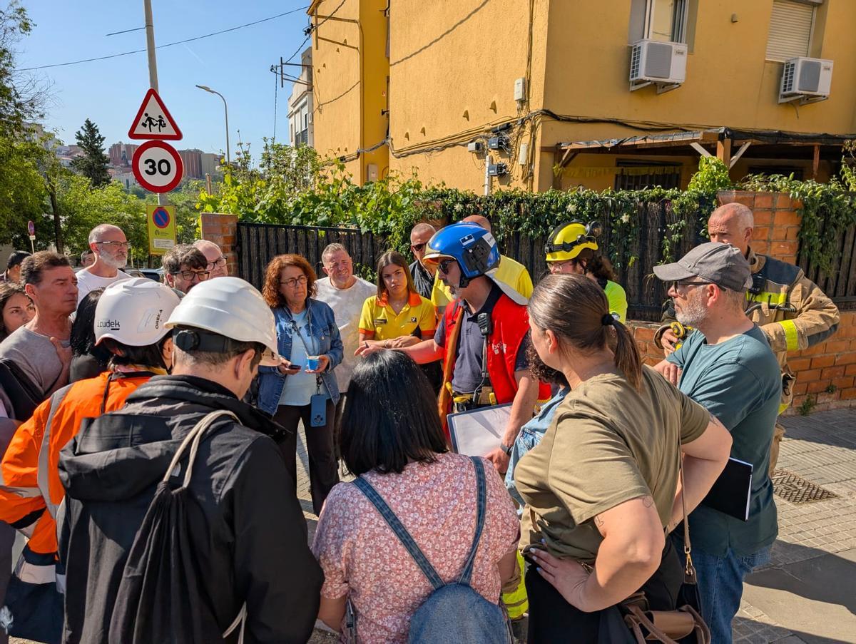 Operarios de los Bomberos explican a los vecinos la situación del inmueble cuya terraza ha colapsado este martes en Santa Coloma de Gramenet
