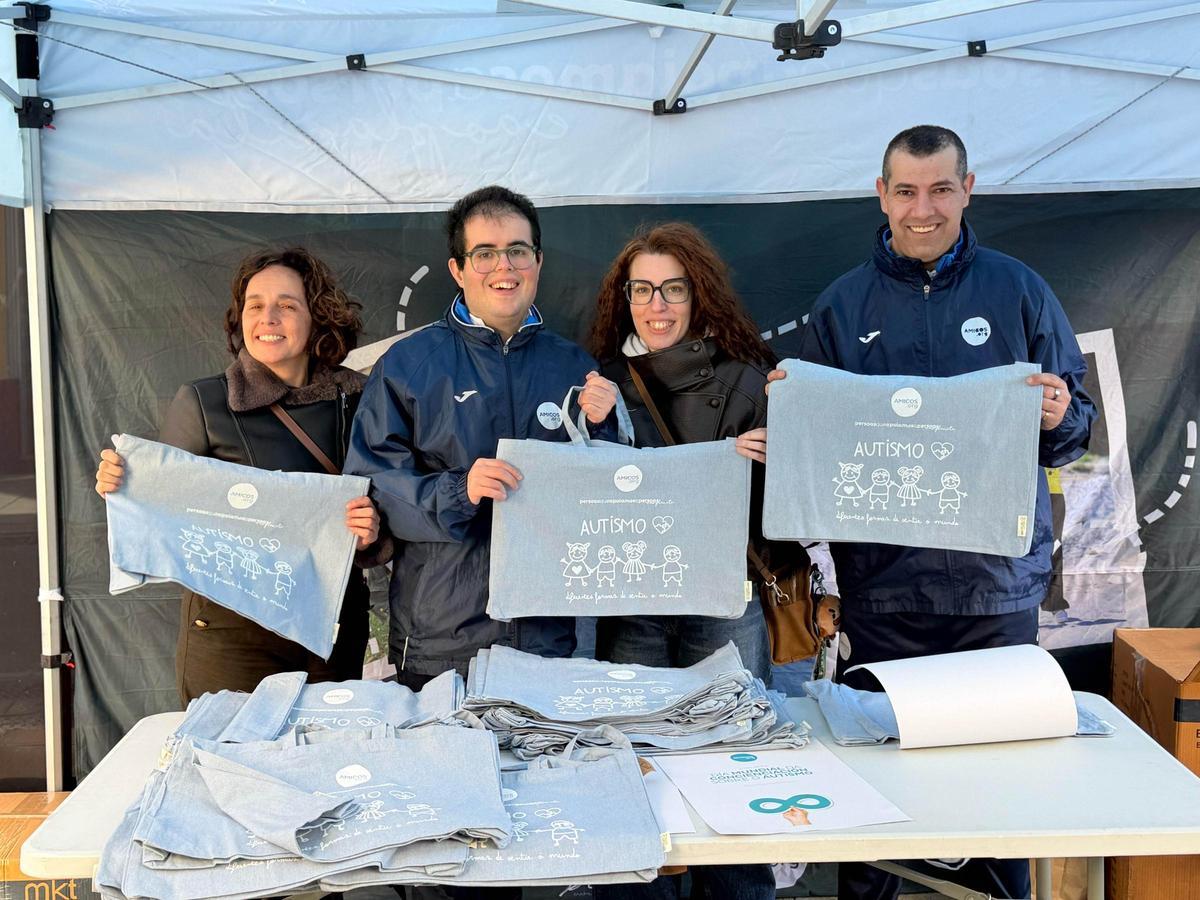 Usuarios de Amicos repartindo bolsas da campaña sobre o autismo.