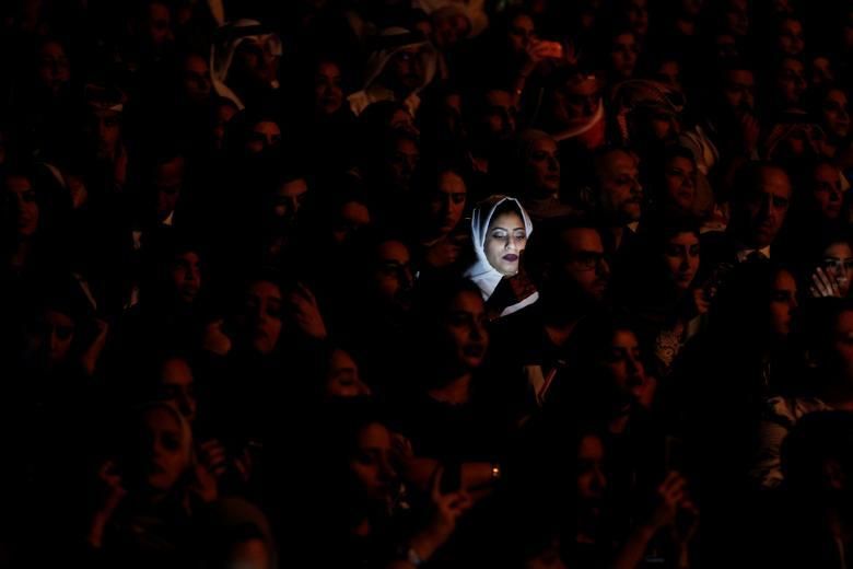 La llum d'un telèfon mòbil il·lumina el rostre de la dona saudita durant la representació en viu del cantant iraquià Majid Al Muhandis com a part de la primavera de la cultura 2017 a Manama, Bahrain, el 10 de març.