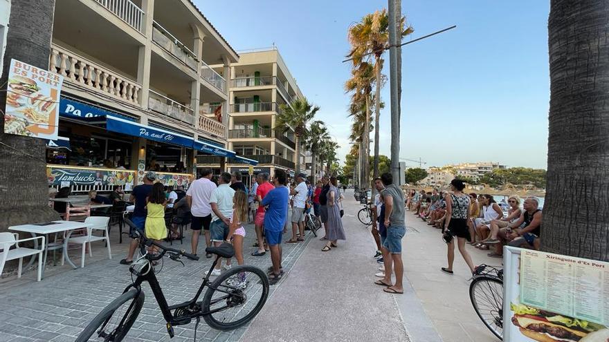 Veraneantes se agolpan durante el quinto set ante la pantalla de un bar de la primera línea peatonal del puerto de la Colònia de Sant Jordi