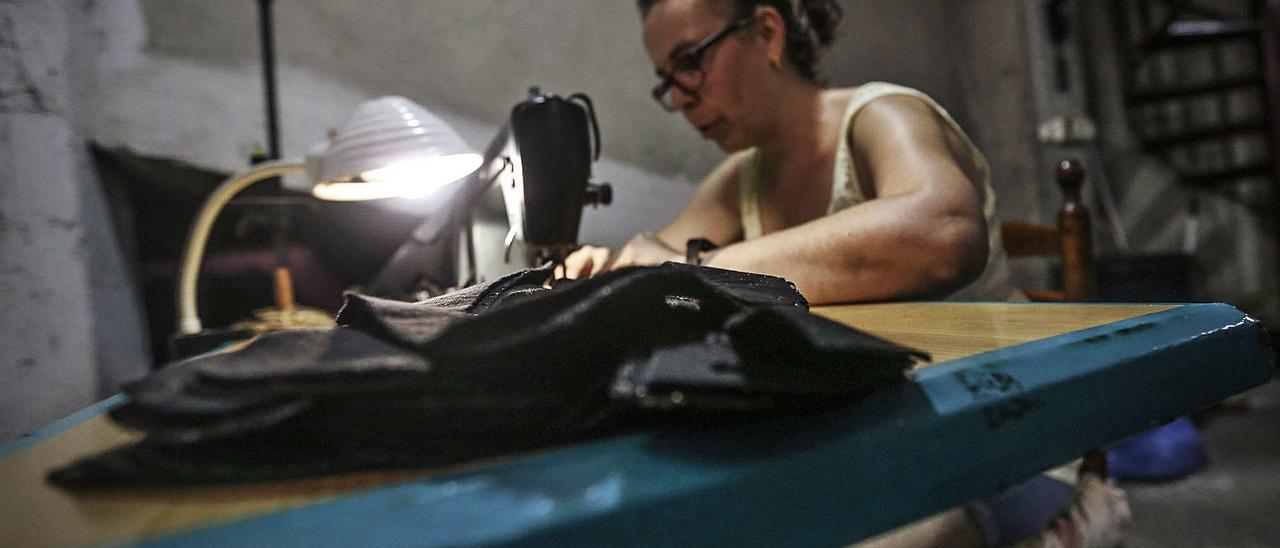 Una aparadora realiza su labor en uno de los talleres que están repartidos por la provincia de Alicante. | TONY SEVILLA