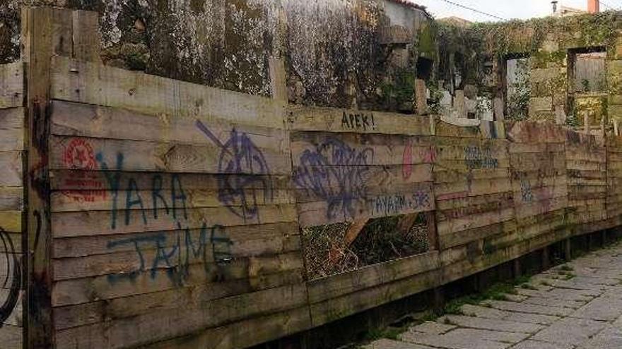 Un agujero en la valla permite arrojar basura al interior.  // R. Vázquez