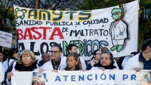 Varias personas con pancartas participan durante una concentración de sanitarios en el arranque de la segunda semana de huelga de médicos y pediatras de Atención Primaria, frente a la Consejería de Hacienda