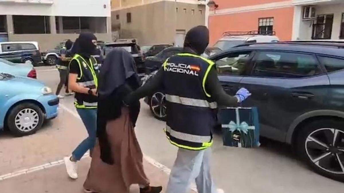 Dos agentes de la Policía Nacional conducen detenida a una mujer por proselitismo yihadista en noviembre de 2025