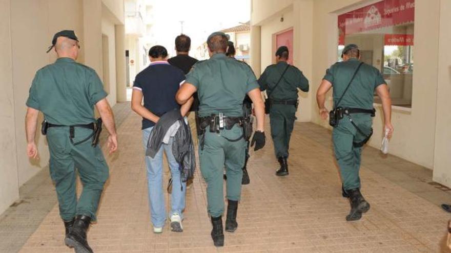 Los guardias civiles trasladan esposados por las calles de Altea a dos de los iraníes detenidos, G.H. y M.G.