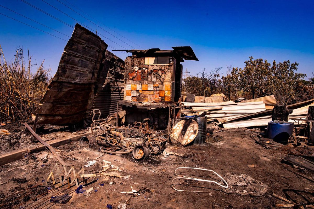 El 1 de julio de 2025, un día después del incendio, la imagen de las barracas cercanas al Port de Barcelona muestra los restos de un asador, lo que parece ser parte de un vehículo pequeño y varias chapas que alguna vez formaron paredes y techos de las viviendas.