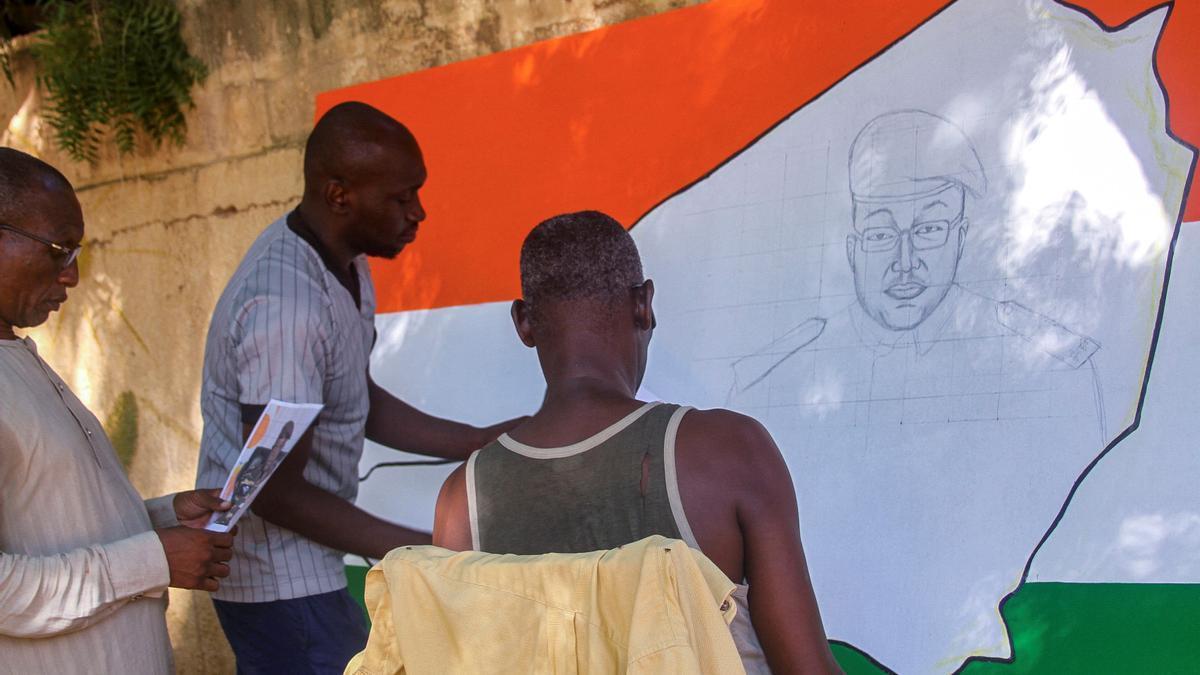 Varias personas dibujan un retrato del general Tiani en Niamey, Níger.