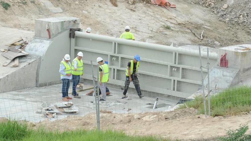 Trabajadores instalando la nueva presa que se someterá hoy a la primera prueba.