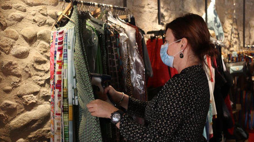Una dependenta d&#039;una botiga de Girona planxant la roba durant el primer dia de reobertura en la fase 1