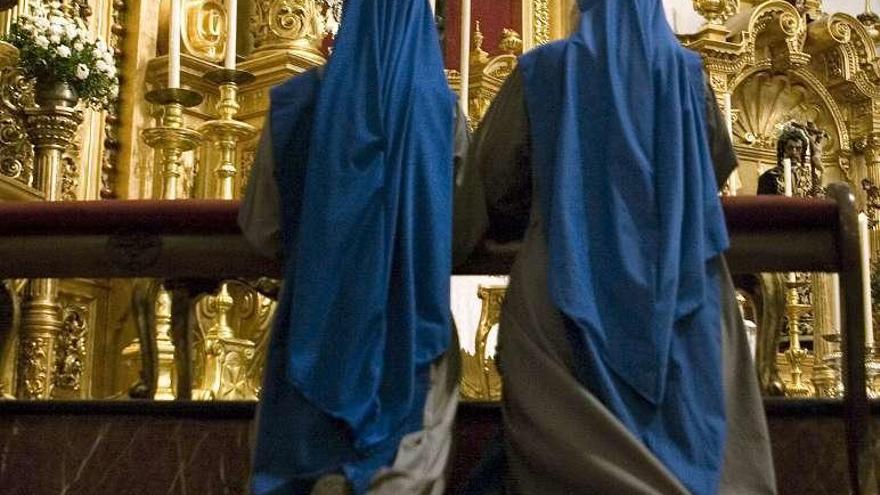 Dos monjas rezan en una iglesia.