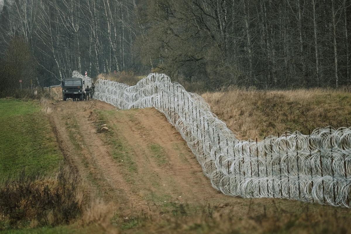 Soldados del ejército polaco arreglan bobinas de alambre de púas en una valla a lo largo de la frontera polaca, con el enclave ruso de Kaliningrado, cerca de Zerdziny, Polonia