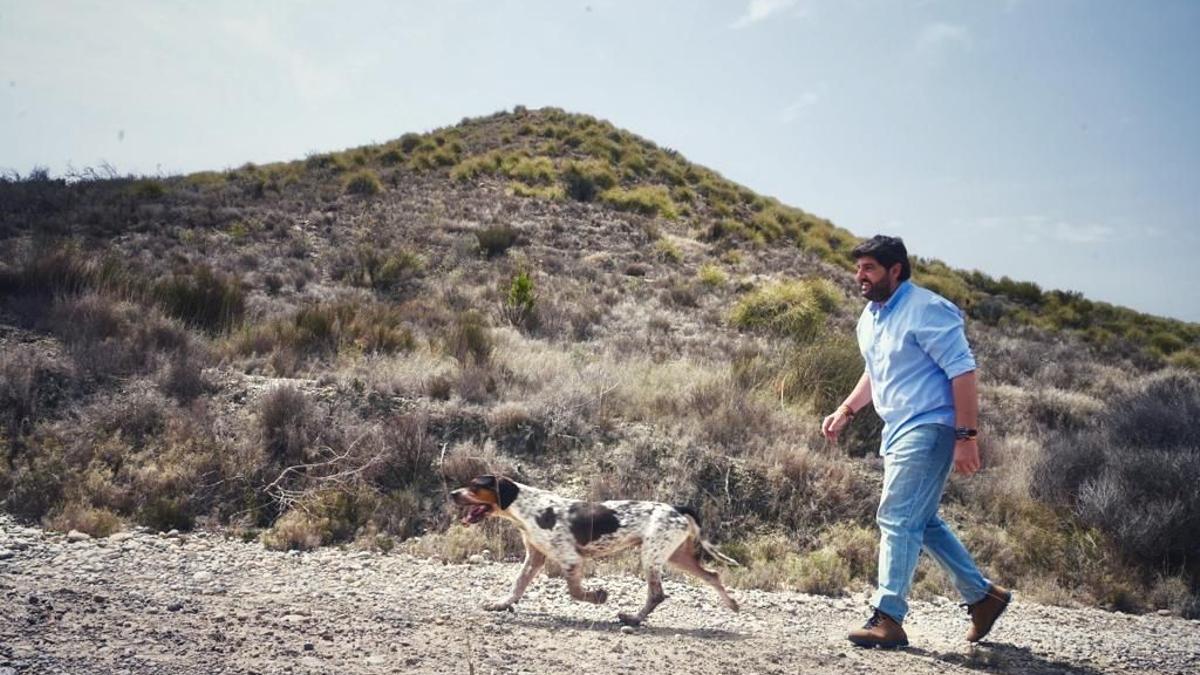 López Miras, candidato del PP, pasea con su perro Pepe por un monte de Murcia.