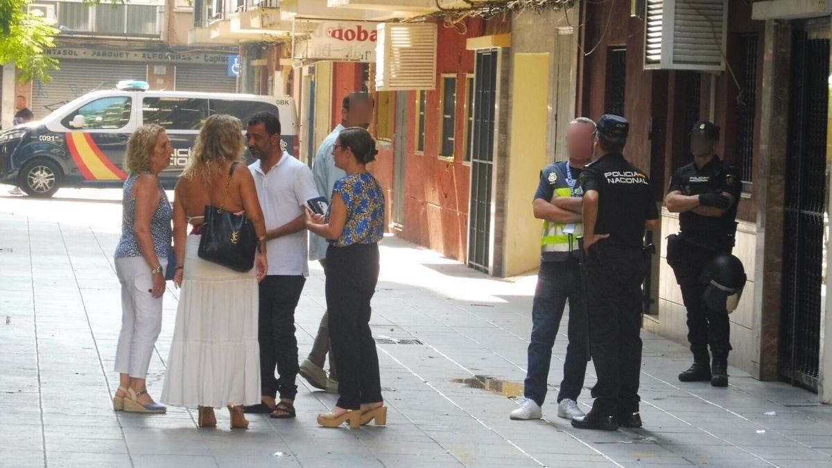 Said y la propietaria, María, conversan en presencia de la concejala, comitiva judicial y agentes.