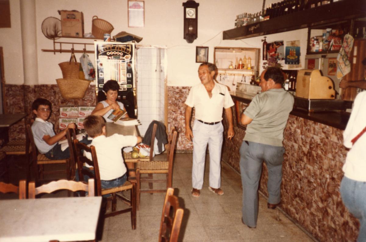 Maria Marí Serra, sentada a la mesa de Can Rafal son sus hijos Vicent y Juan Antonio