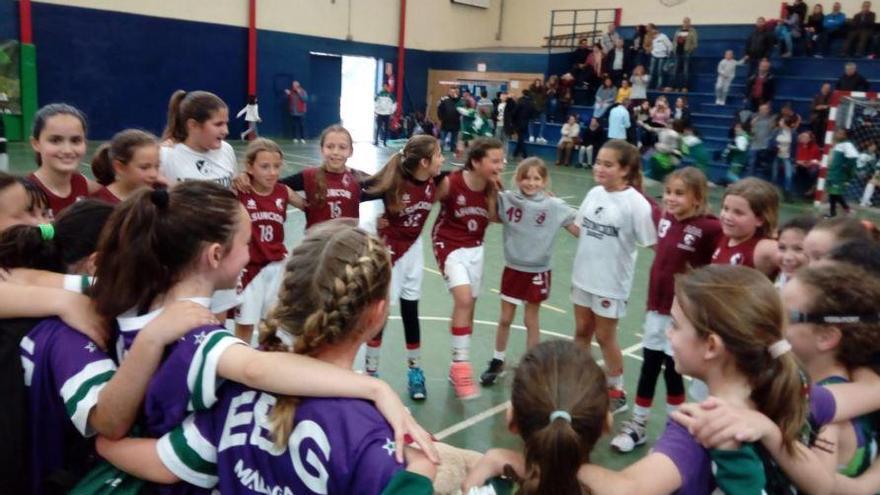 Dos equipos de niñas festejan juntas el final de un partido.