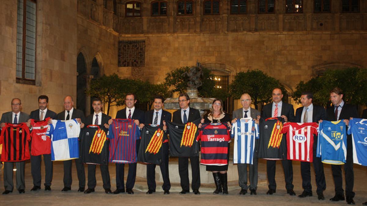 Foto de familia de los presidentes de los clubes de fútbol que firmaron el convenio de apoyo a las selecciones catalanas, el lunes en el Palau, con Artur Mas.