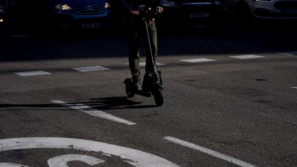 Una persona con un patinete eléctrico circula por el centro de la ciudad.
